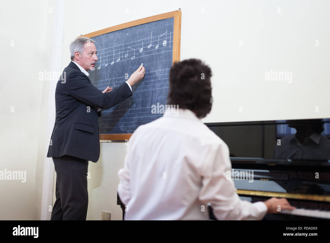 Teacher giving piano lesson in a conservatory Stock Photo