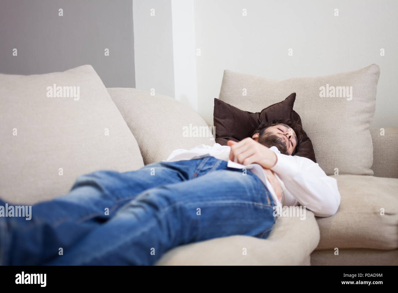 Young Tired Man Sleeping At Home On His Couch Stock Photo - Alamy