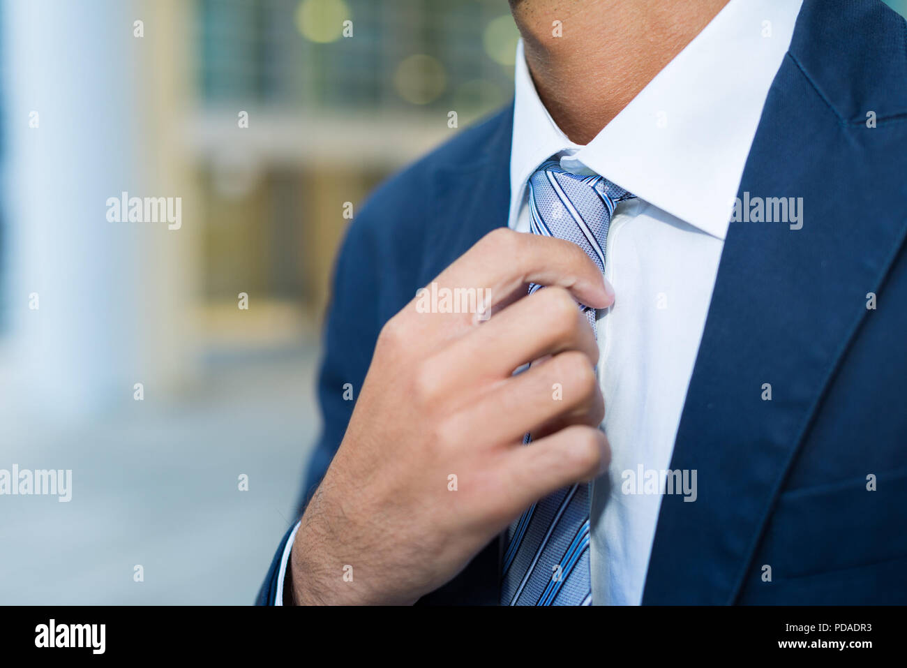 Detail of a businessman adjusting his tie Stock Photo