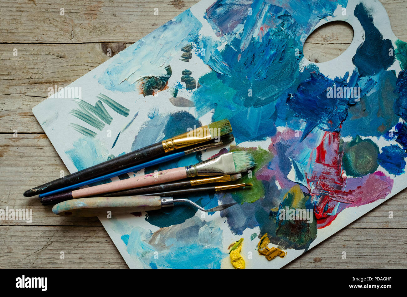 Artist paint brushes on wooden palette. Texture mixed oil paints in  different colors. Instruments and tools for creative leisure. Painting  hobby backg Stock Photo - Alamy