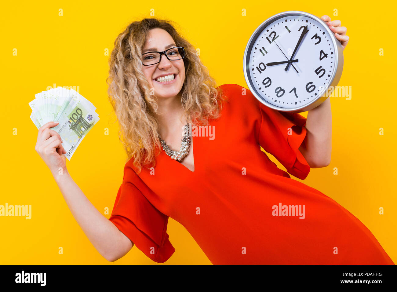 Woman in dress with clocks and fan of banknotes Stock Photo