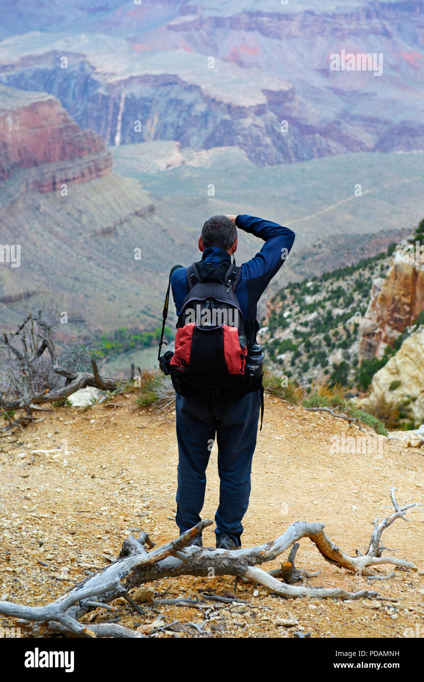 Man taking a picture of the Grand Canyon from the South Rim. Stock Photo