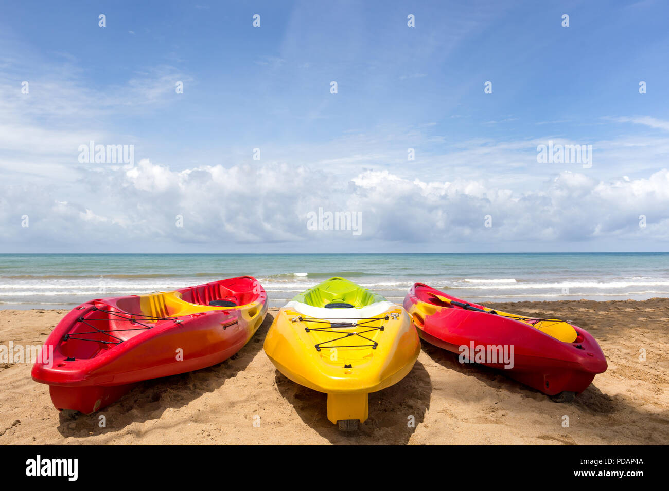 Colorful sea kayaks on sand beach with ocean and blue sky Stock Photo ...