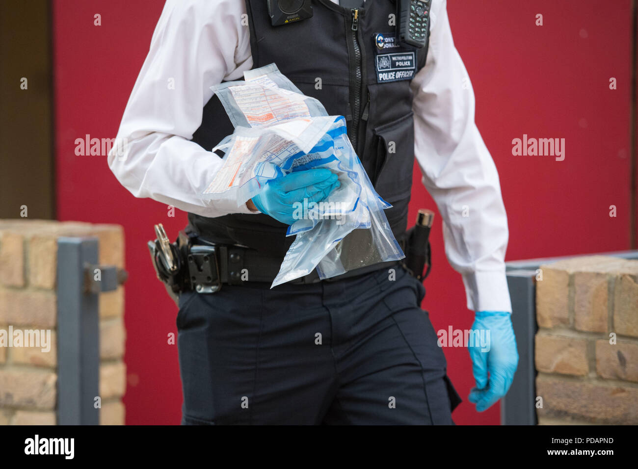 A police officer removes drugs and other evidence from an address in