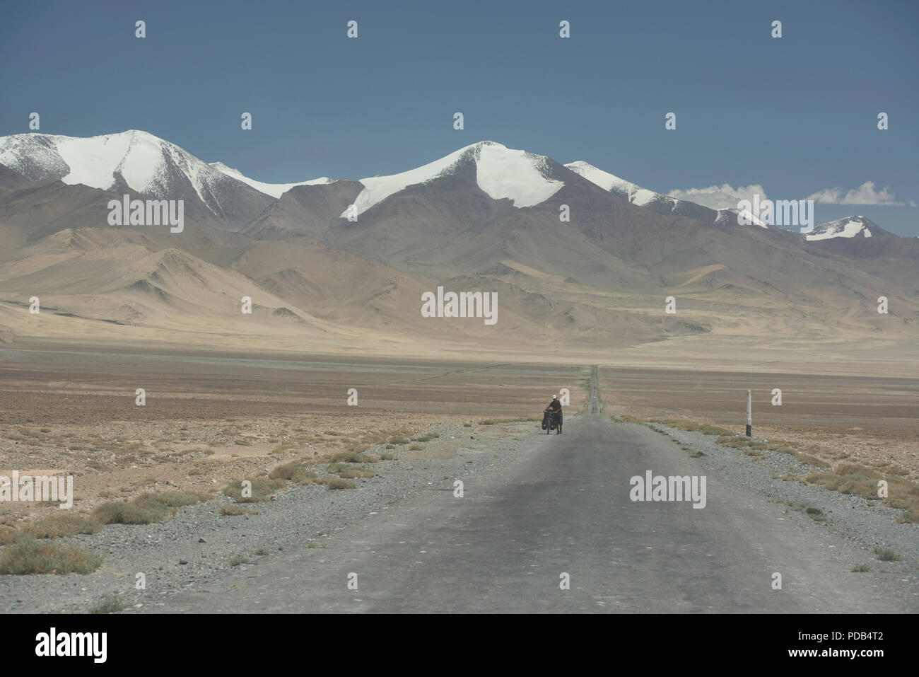 A lone bicyclist on the Pamir Highway, Tajikistan Stock Photo