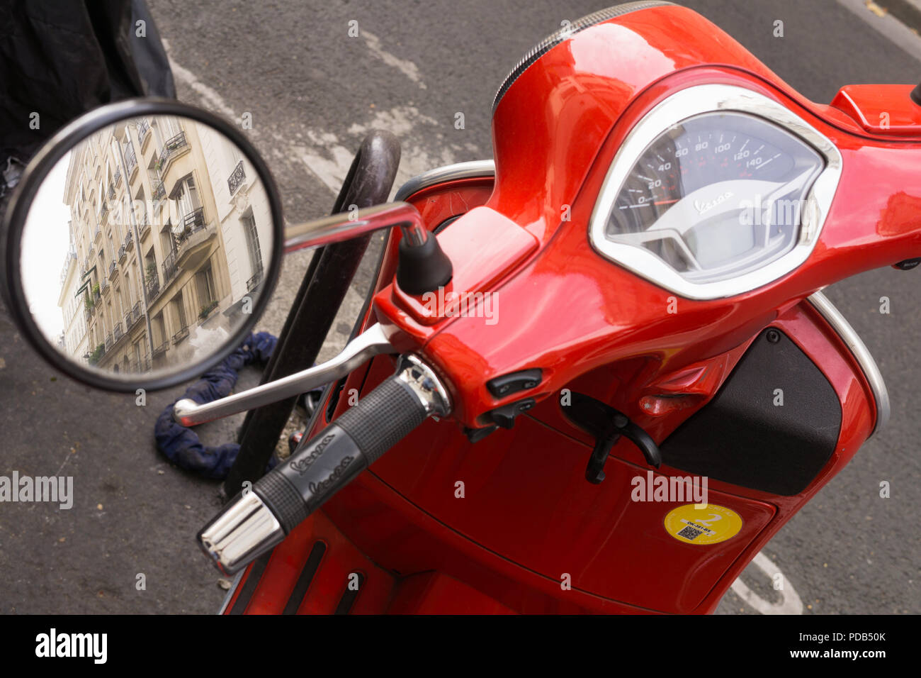 Red vespa - Reflection of Paris buildings in the rearview mirror of red Vespa. Stock Photo