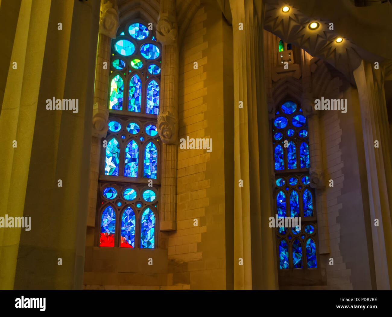 Colorful geometric stained glass windows in the Sagrada Familia - large unfinished Roman Catholic church in Barcelona, designed by Catalan architect A Stock Photo