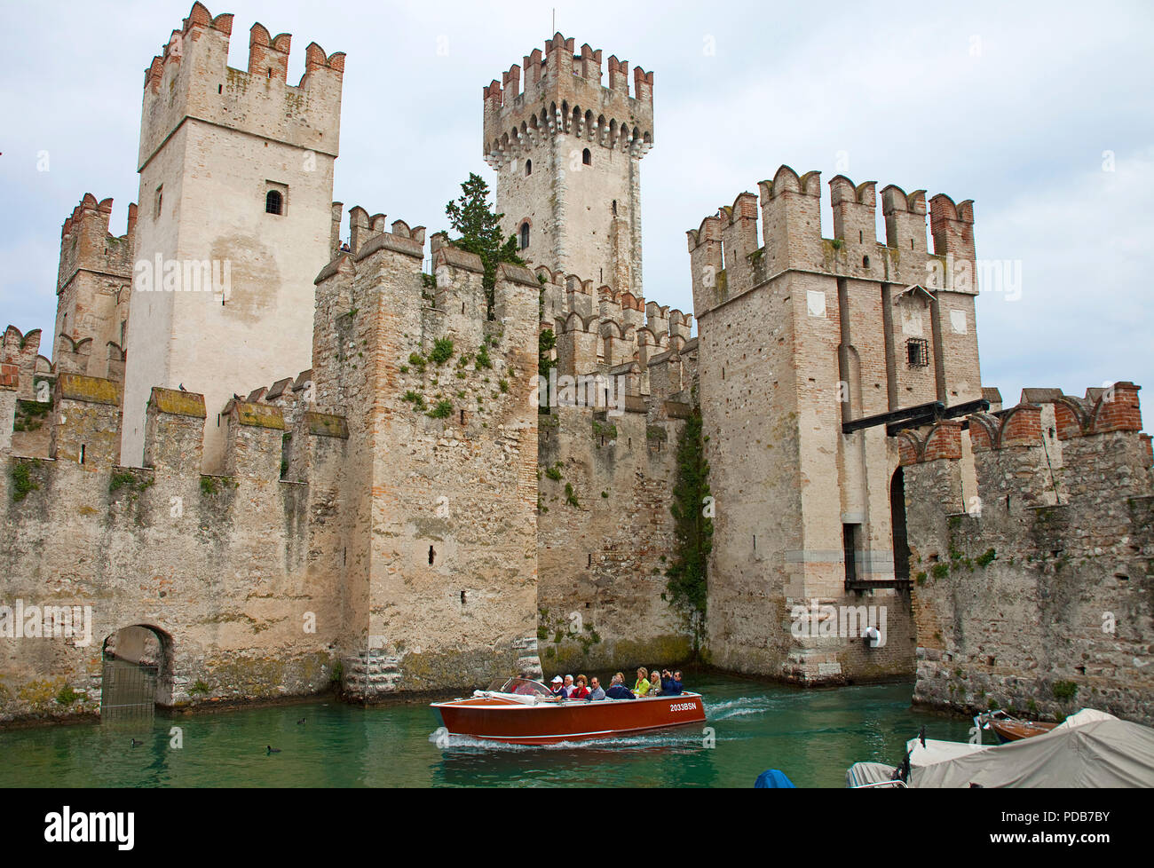 Roundtrip-boat at the Scaliger castle, landmark of Sirmione, Lake Garda, Lombardy, Italy Stock Photo