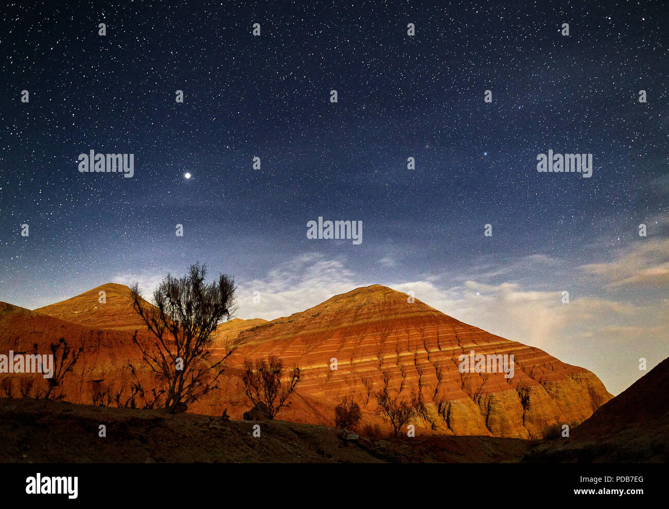 Red mountains in the canyon desert at night starry sky background. Astronomy photography of space and landscape. Stock Photo