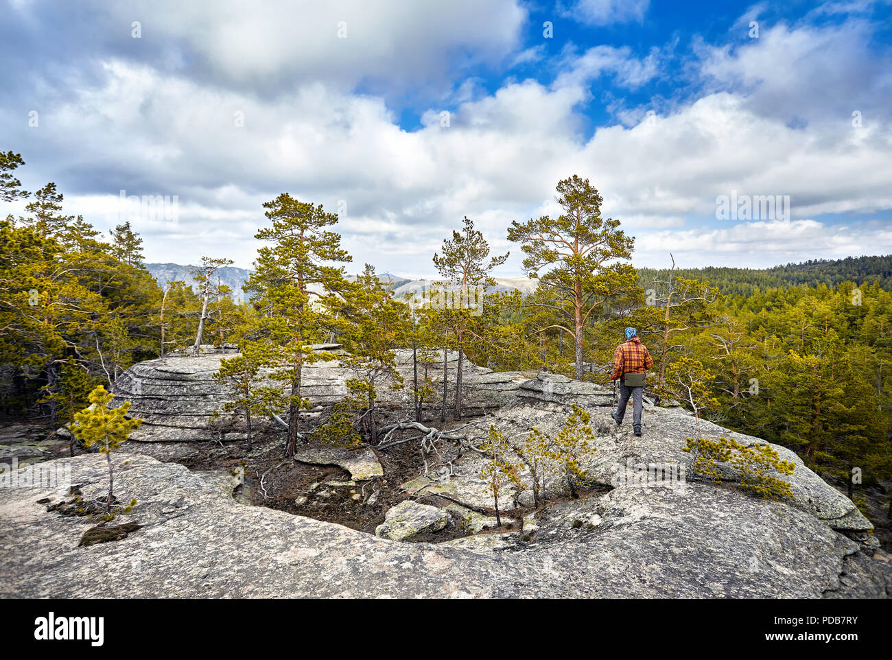 Man in brown jacket walking to the beautiful forest in Karkaraly national park in Karkaralinsk, Central Kazakhstan Stock Photo