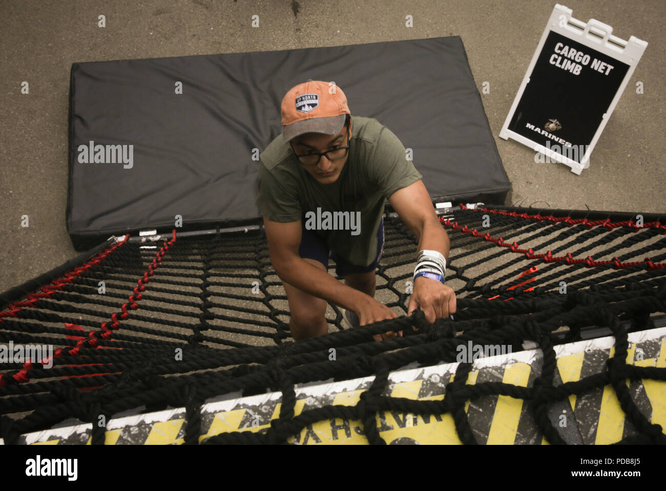 MADISON, Wisconsin – Jay Singh, a native of Glendale, WI, climbs the rope  ladder at the Marine Corps Battles Won Challenge trailer during the 2018  Reebok CrossFit Games at the Alliant Energy