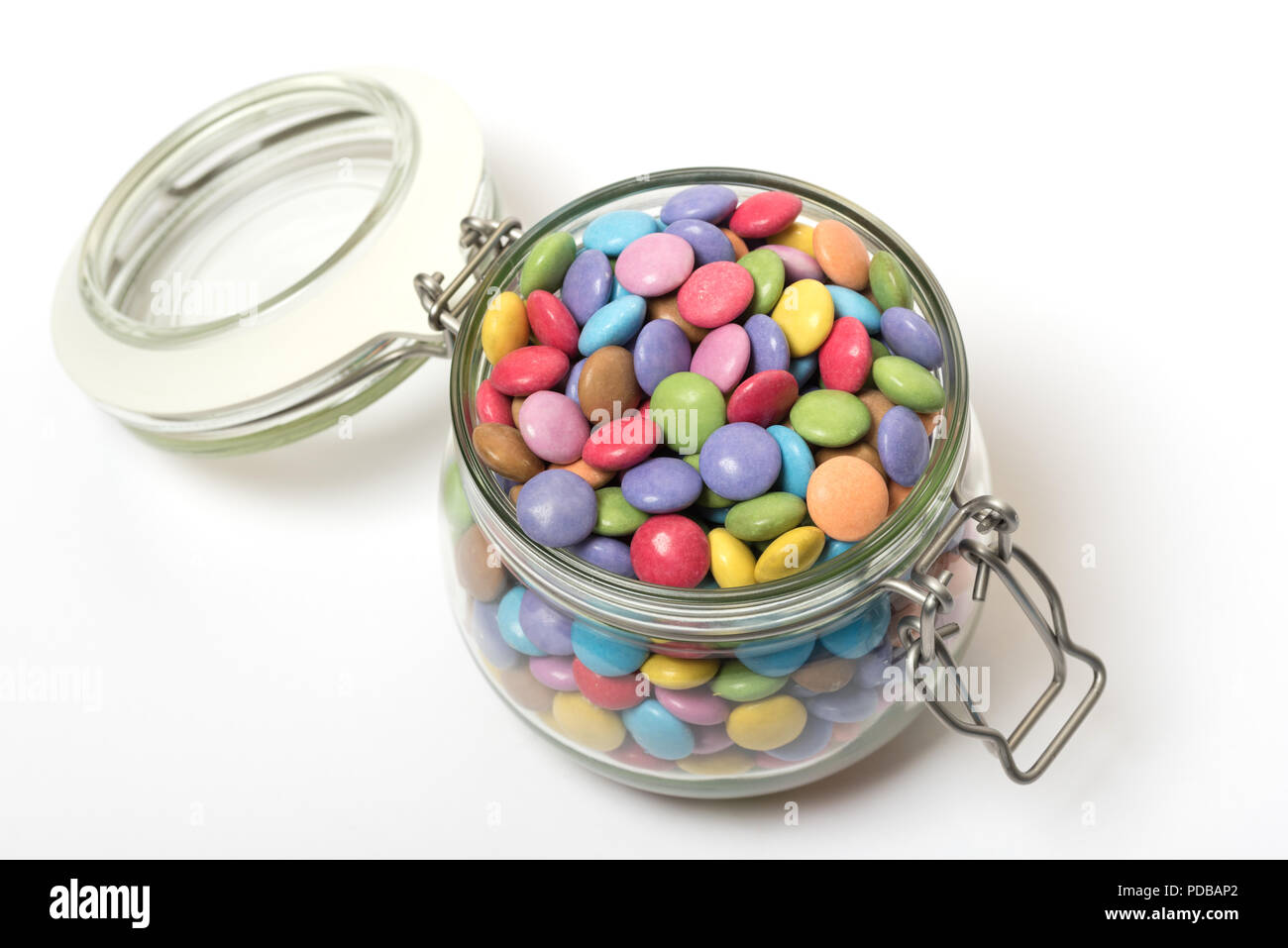 opened packet of crispy M&Ms with contents spilt to spell letters M  isolated on white background Stock Photo - Alamy