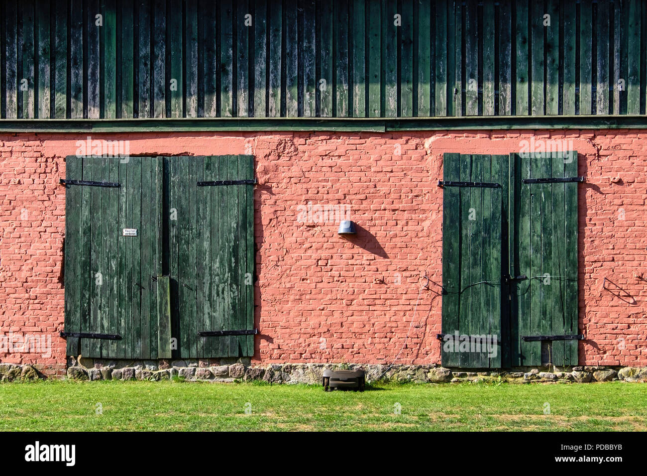 Germany,Stolpe an der Peene, Gutshaus Stolpe Estate. Historic old restored farm building. Old barn with terracotta paintwork & wooden barn doors       Stock Photo