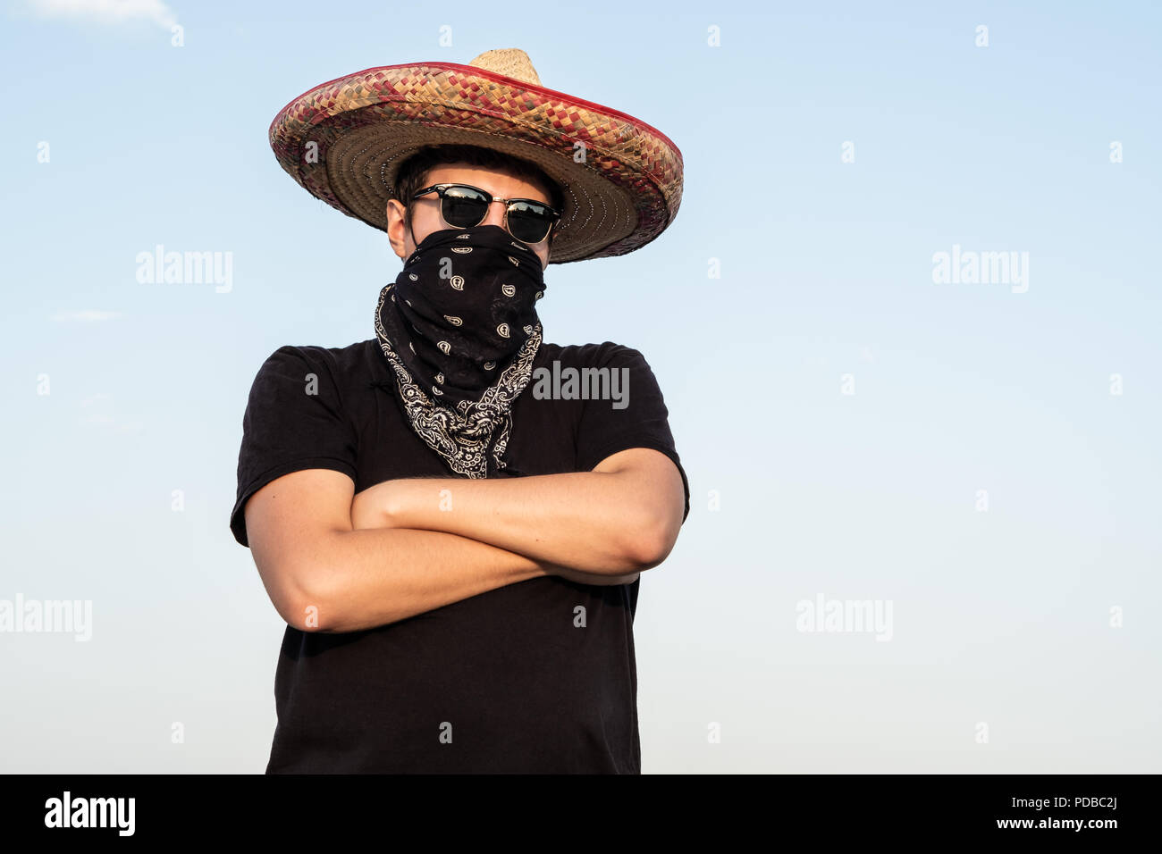 Young male person dressed up as gangster in traditional sombrero, bandana.  Mexican festive or halloween concept of man posing as bandit or western sty  Stock Photo - Alamy