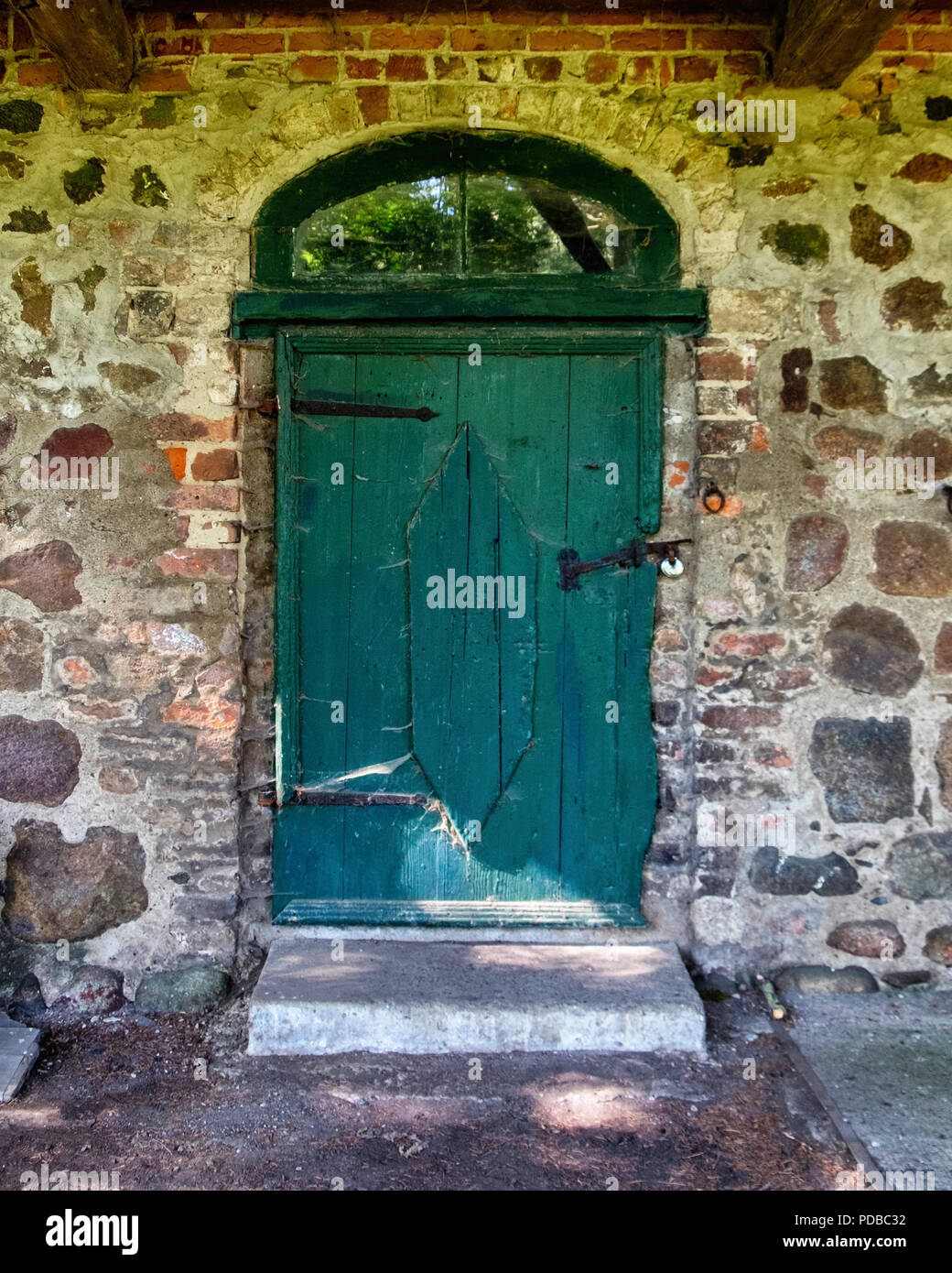 Germany,Stolpe an der Peene, Historic old blacksmith on Gutshaus Stolpe Estate grounds Listed stone building detail with green wood door.              Stock Photo