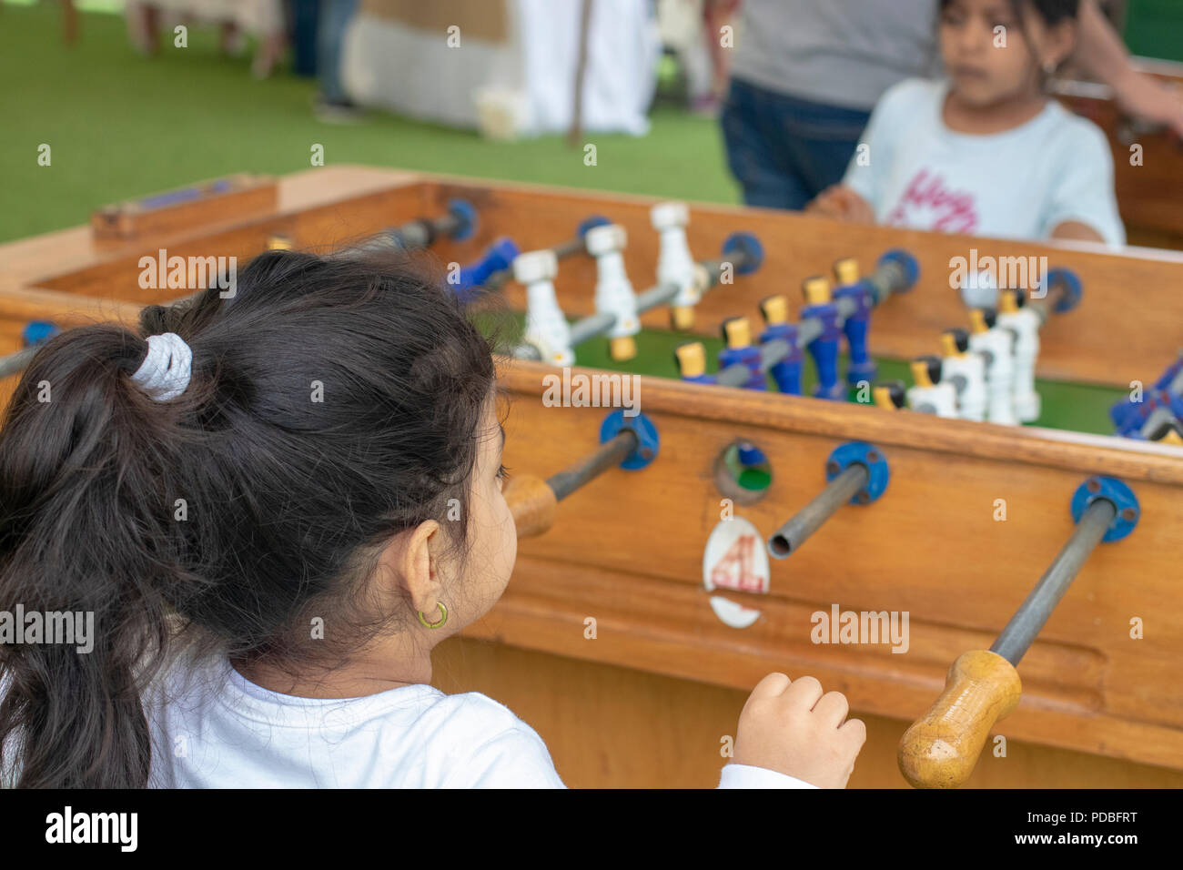 Cute little girl playing table football in the park Stock Photo