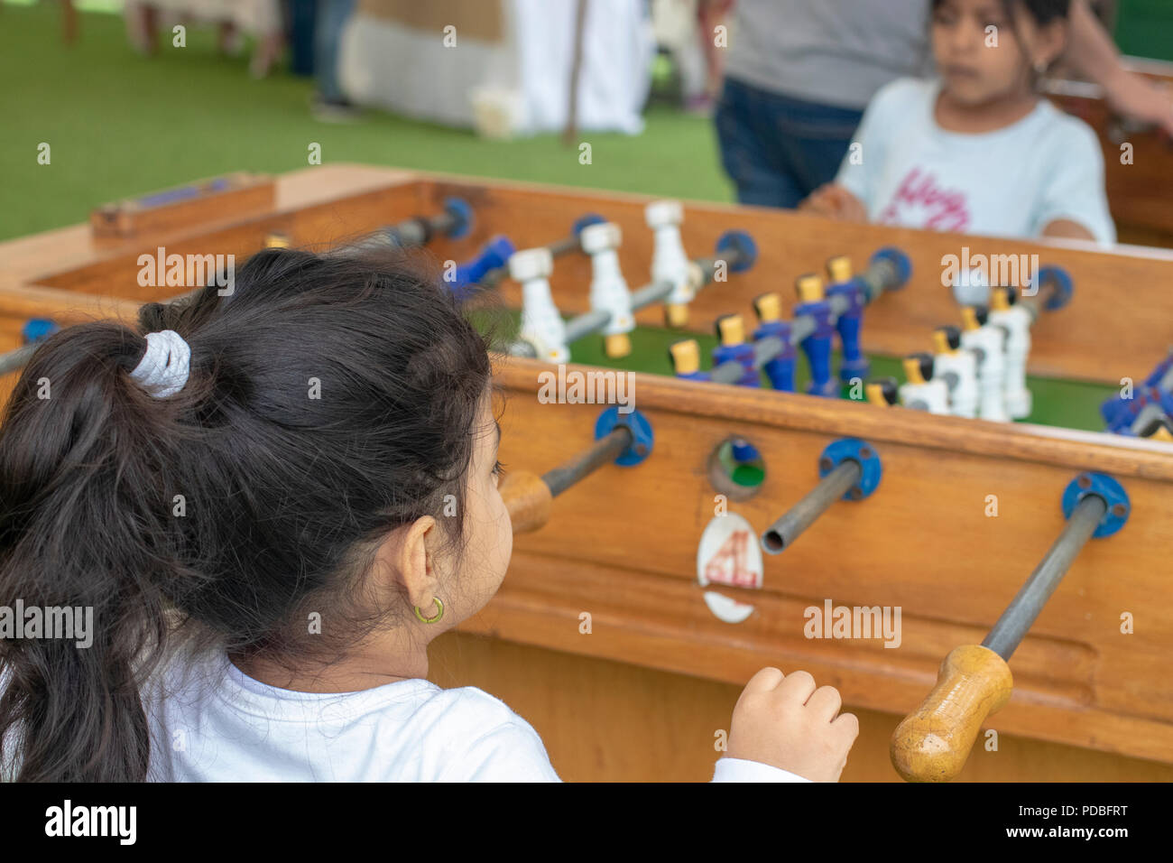 Cute little girl playing table football in the park Stock Photo - Alamy