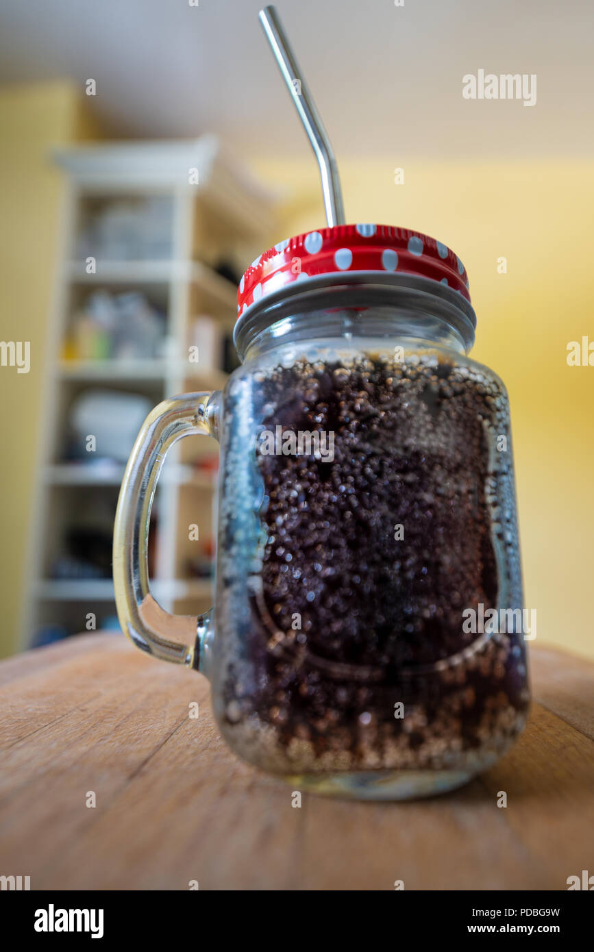Cola in a jar with a handle, red lid with white spots & a stainless steel drinking straw. Stock Photo