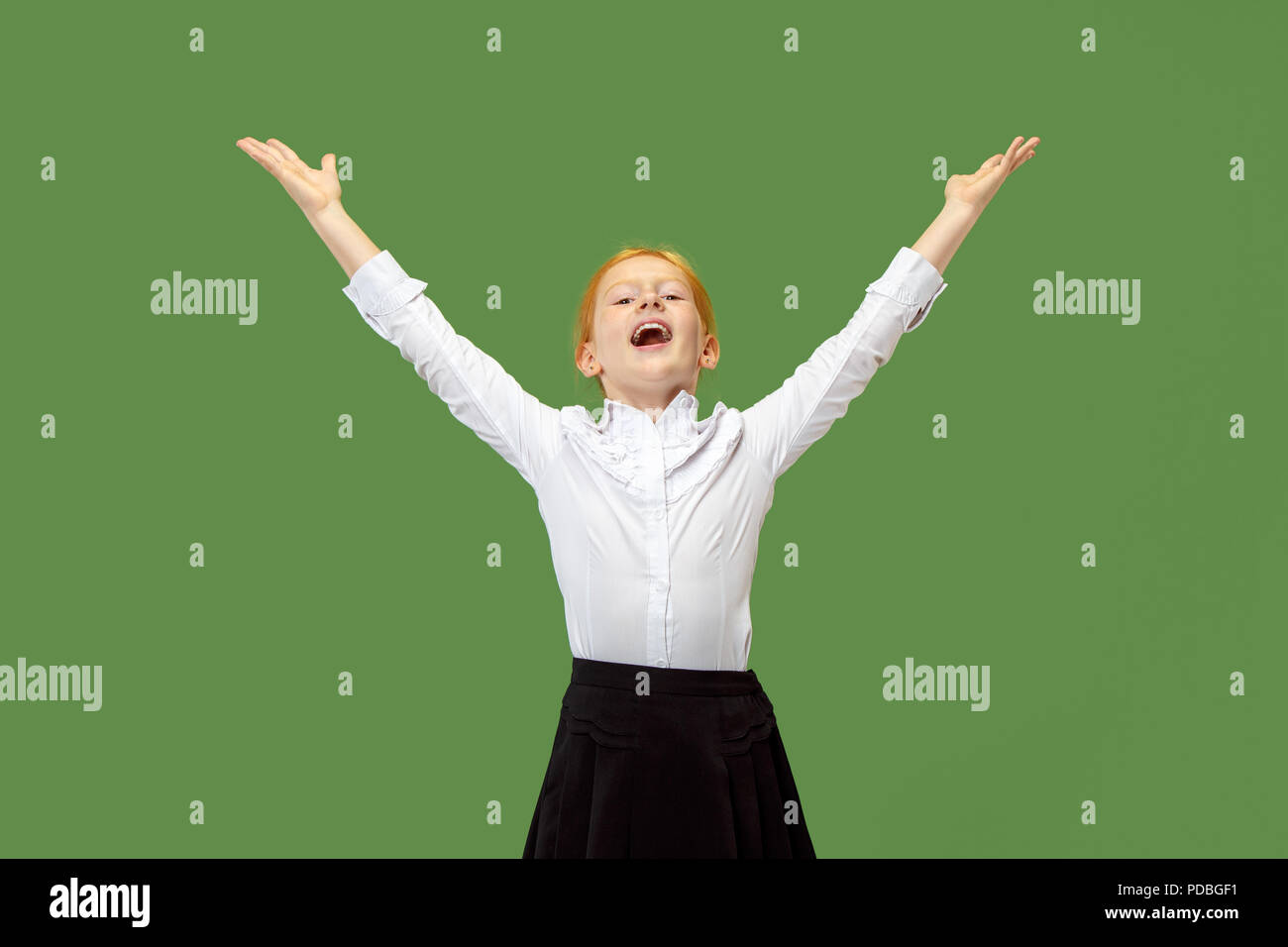 I won. Winning success happy teen girl celebrating being a winner. Dynamic image of caucasian female model on green studio background. Victory, delight concept. Human facial emotions concept. Trendy colors Stock Photo