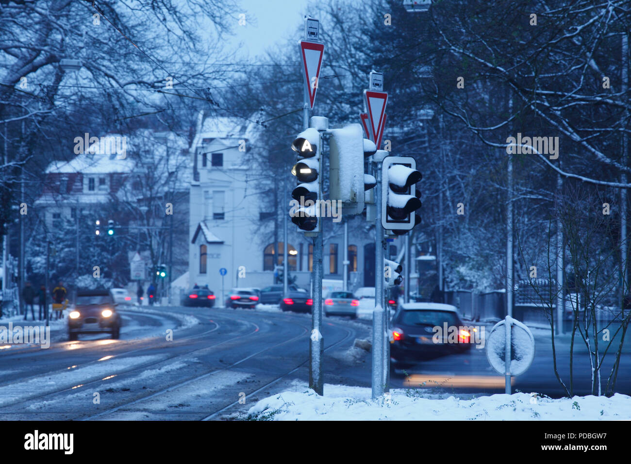 Snowy street with traffic sign in Schwachhausen at dawn, Bremen, Germany, Europe  I Verschneite Straße mit Verkehrszeichen in Schwachhausen bei Morgen Stock Photo