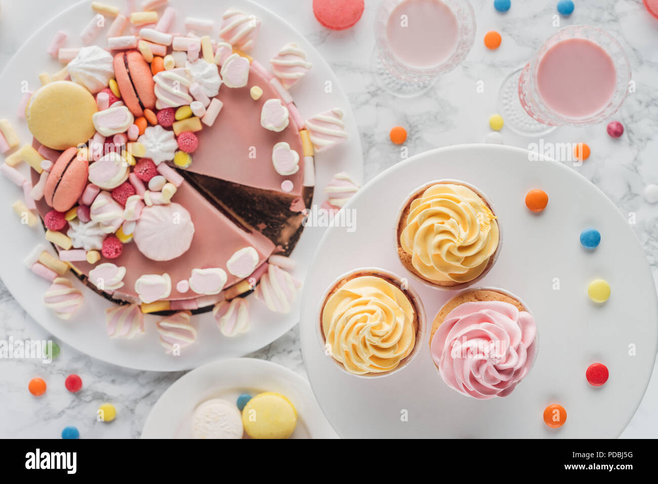top view of birthday cake with marshmallows, cupcakes and milkshakes on table Stock Photo