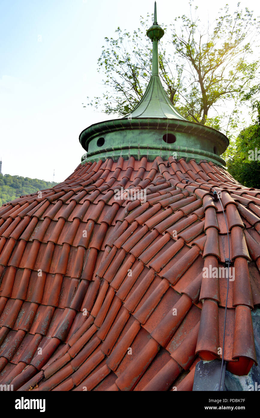 Curved tiled rotunda belvedere roof with detail of red clay roofing tiles and copper cupola on Prague Castle peripheral wall Stock Photo