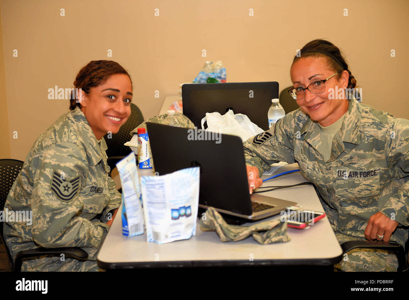 ALPENA, Mich. — Mother and daughter, Master Sgt. Sheila Lipp, a command support staff member of the 127th Maintenance Group, and Tech Sgt. Chanel Daniels, a food service lead of the 127th Force Support Squadron, both units of the Selfridge Air National Guard Base, Mich., work on finalizing their orders after performing an operational readiness assessment at the Alpena Combat Readiness Training Center on Aug. 2, 2018. More than 500 Citizen-Airmen of the 127th Wing mobilized in a simulated deployment that created opportunities to practice their job proficiency while being assessed for wartime ta Stock Photo