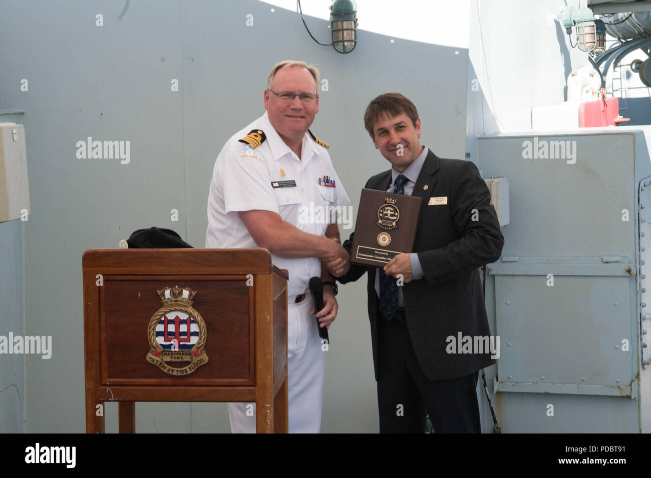 180804-N-DA737-0069 SEATTLE (August 4, 2018) Capt. Steve Jorgensen, deputy commander of Canadian Fleet Pacific, presents a plaque to Seattle Navy League President Jeff Davis during a reception held aboard Kingston-class coastal defense vessels HMCS Whitehorse (710) and HMCS Yellowknife (706) during Seattle’s Seafair Fleet Week. Seafair Fleet Week is an annual celebration of the sea services wherein Sailors, Marines and Coast Guard members from visiting U.S. Navy and Coast Guard ships and ships from Canada make the city a port of call. (U.S. Navy photo by Mass Communication Specialist 2nd Class Stock Photo
