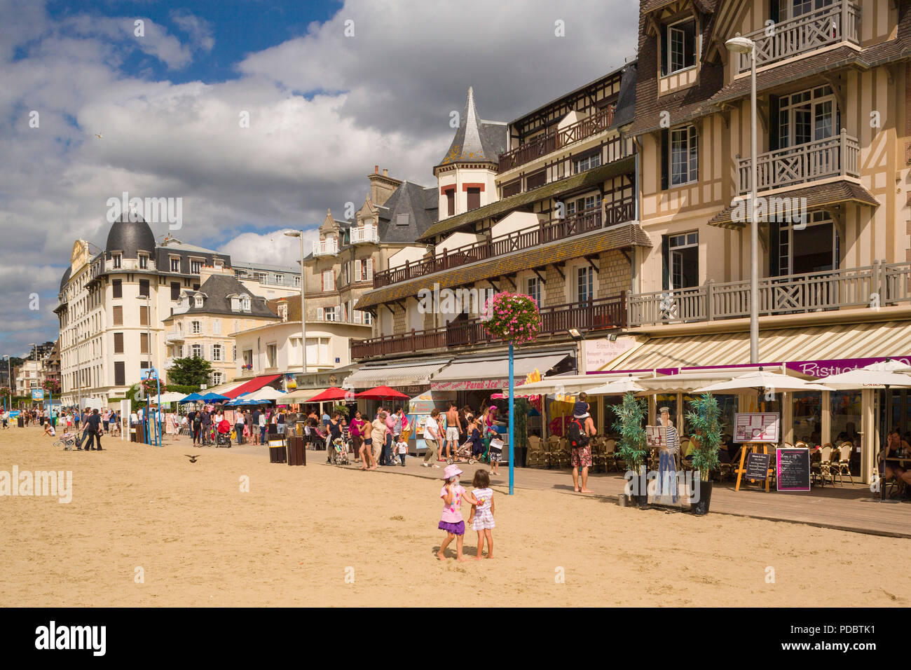 Holidaymakers on the seafront by the sandy beach and boardwalk at Trouville-sur-Mer, Normandy, France Stock Photo