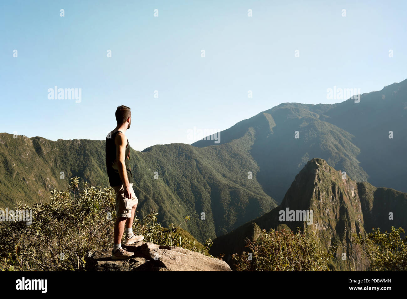 Man sideways overlooking at Machu Picchu city from Machu Picchu Mountain. UNESCO World heritage site. Jul 2018 Stock Photo