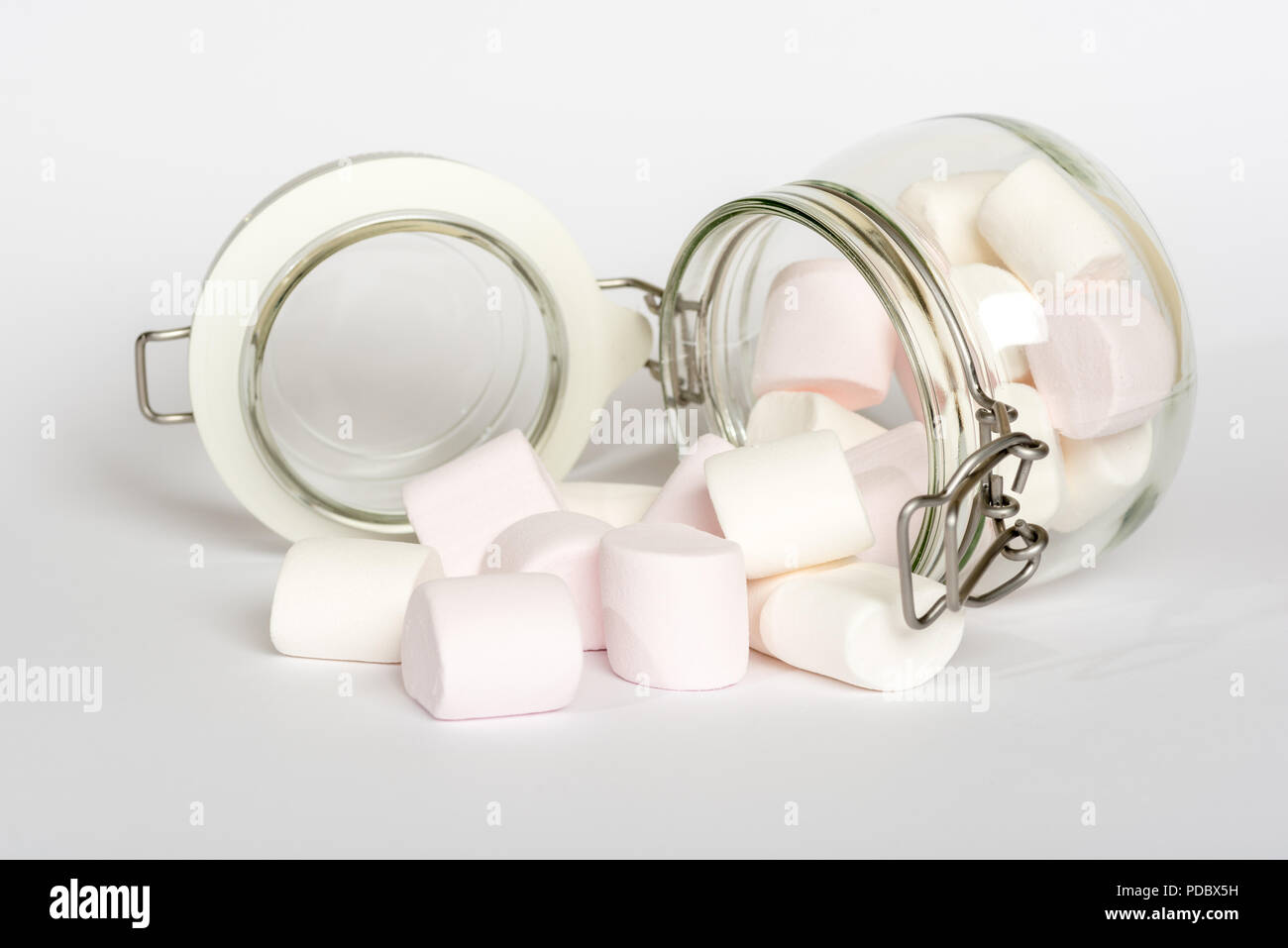Pink and white marshmallow candies in glass clip top food storage jar isolated on white background Stock Photo