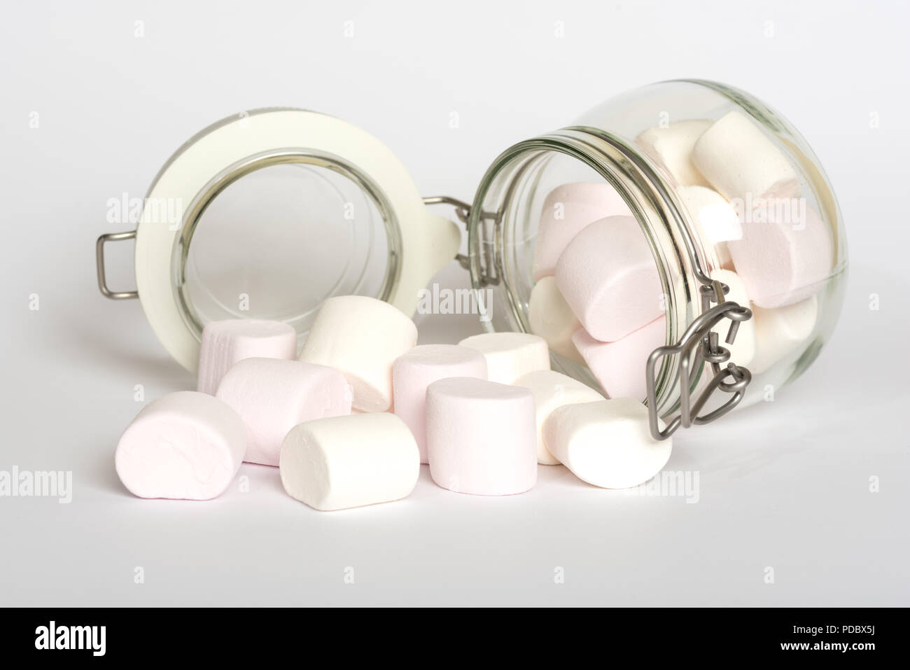 Pink and white marshmallow candies in glass clip top food storage jar isolated on white background Stock Photo