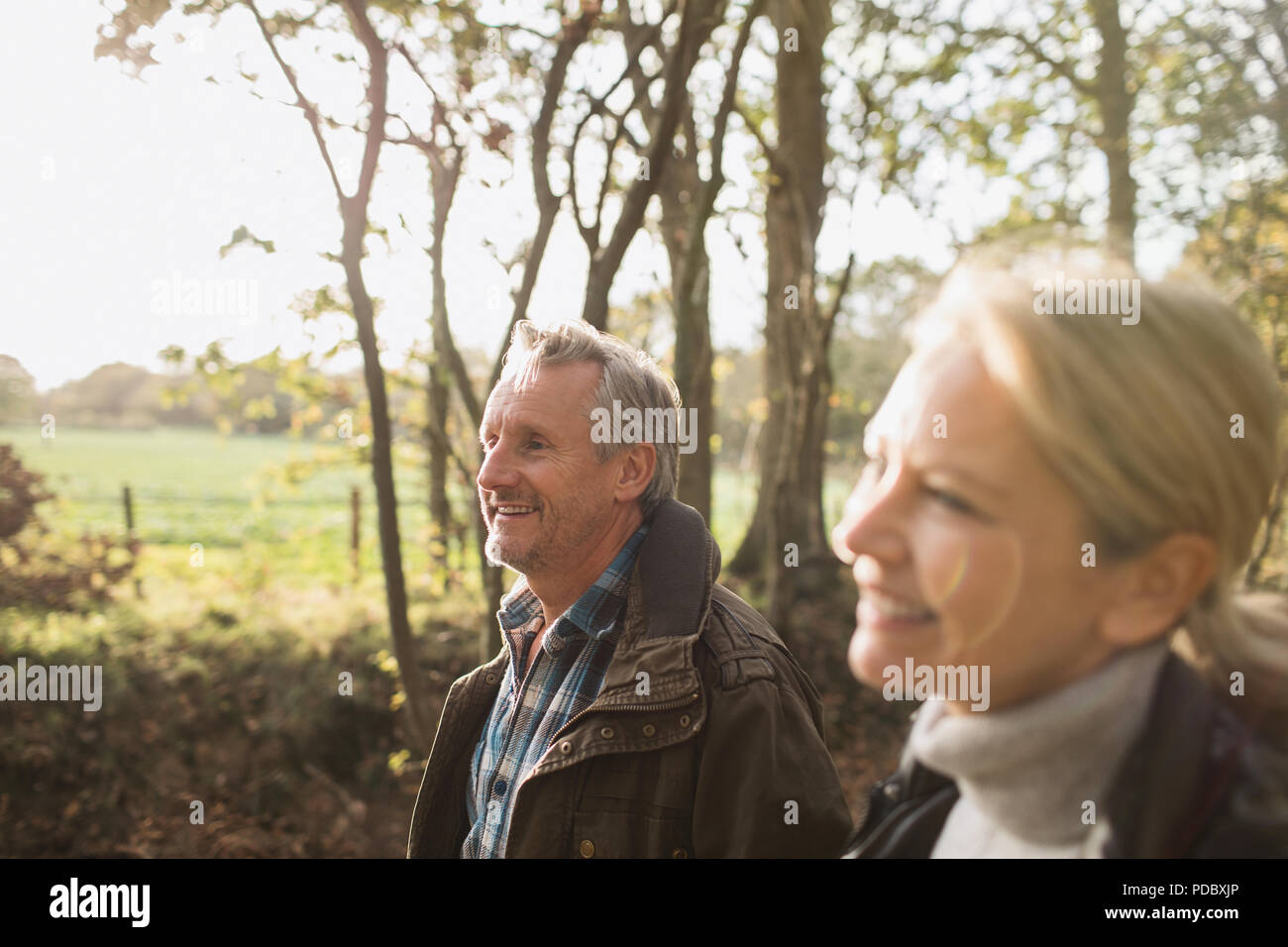 Happy mature couple walking in sunny autumn park Stock Photo