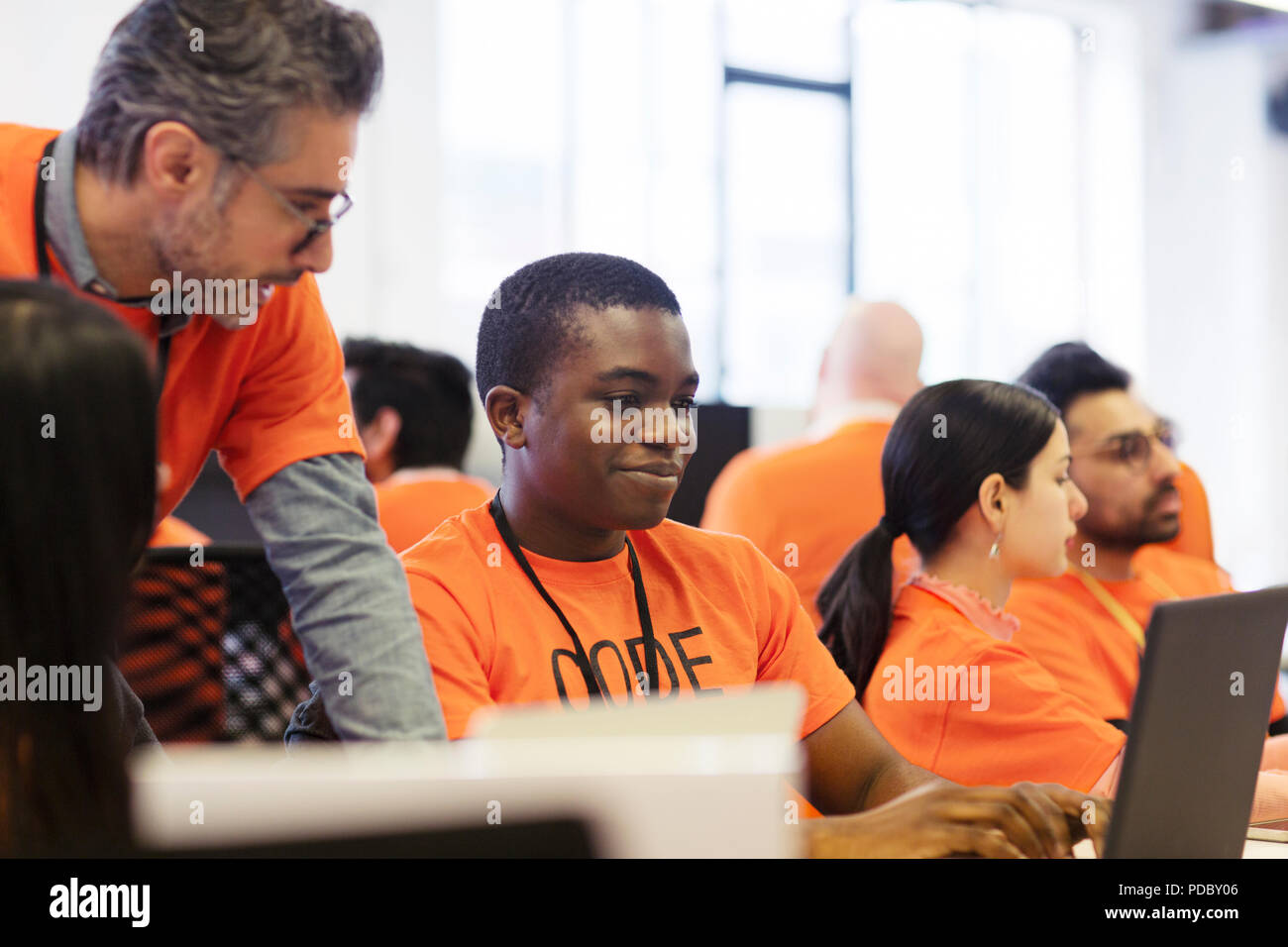 Hackers at laptops coding for charity at hackathon Stock Photo