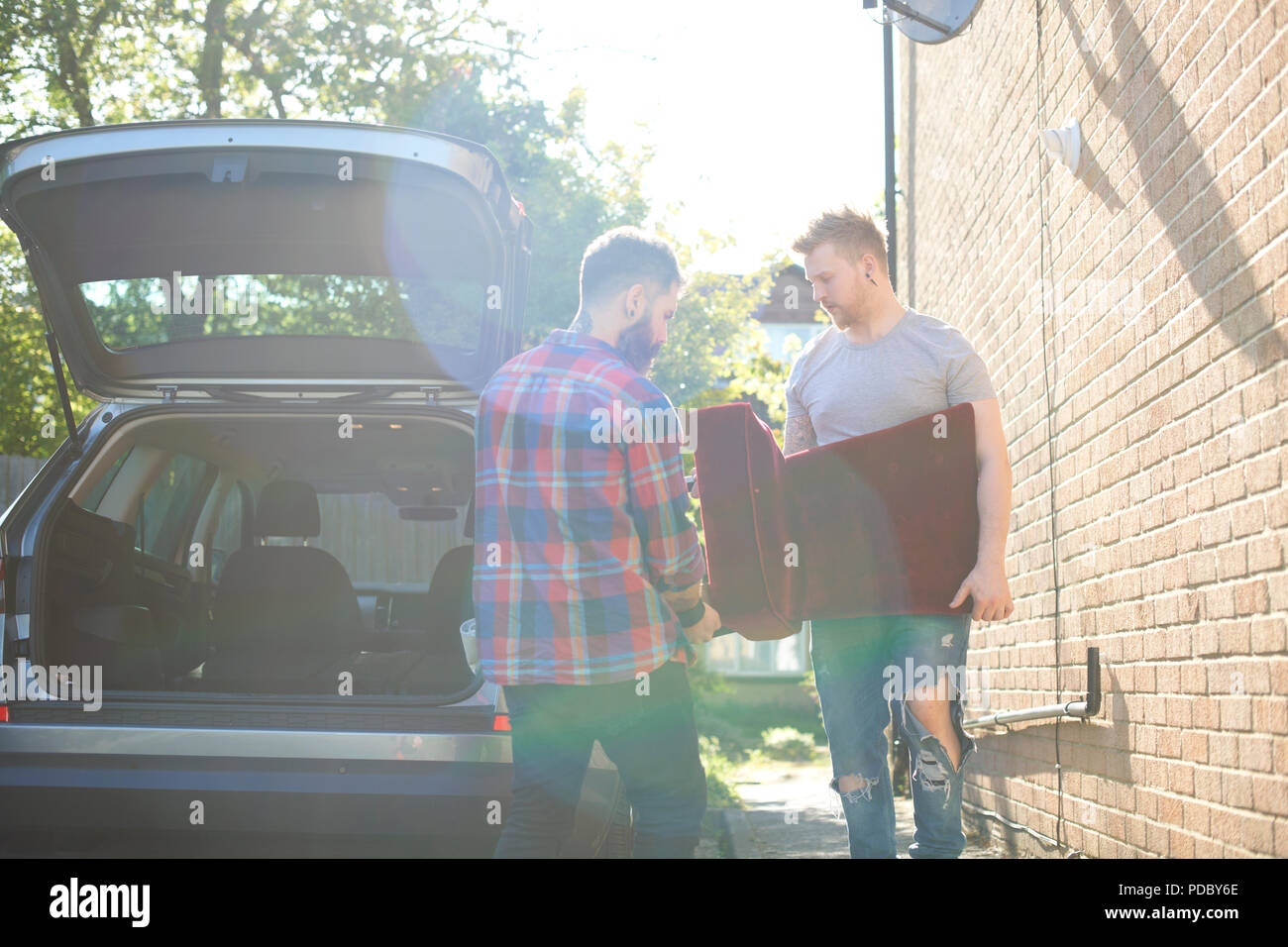 Male gay couple moving furniture Stock Photo