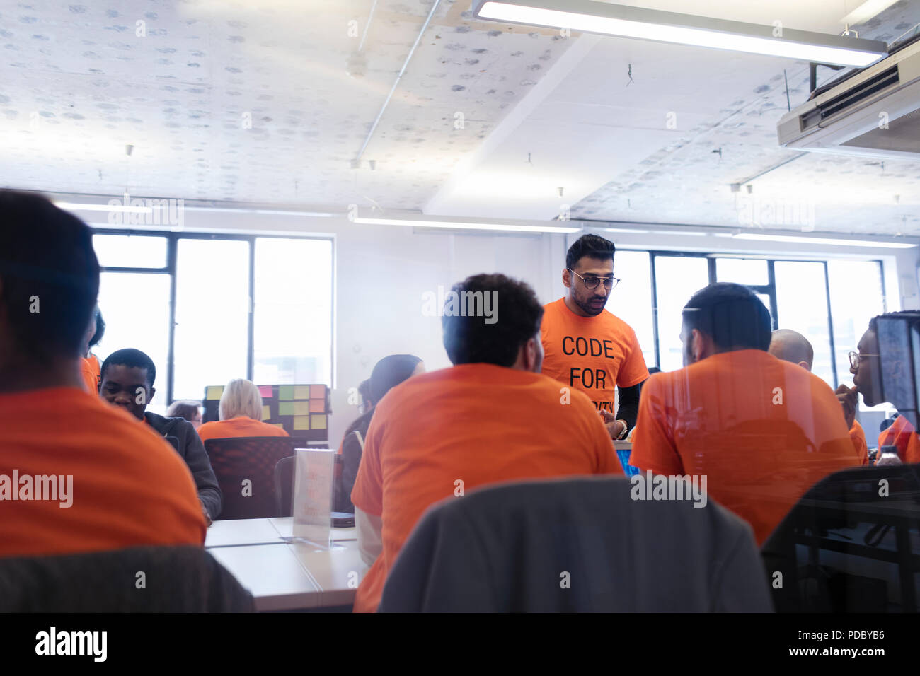 Hackers coding for charity at hackathon Stock Photo