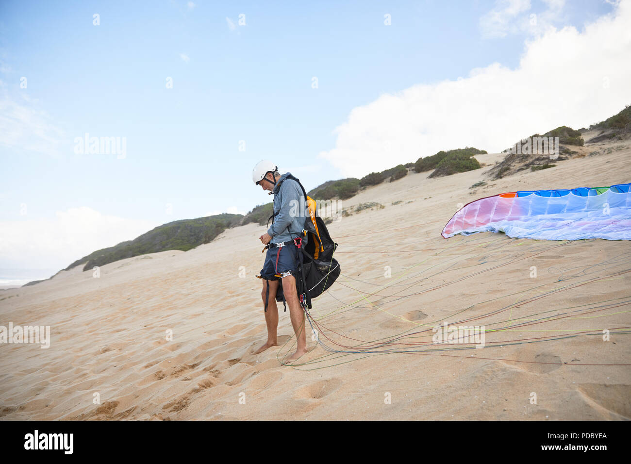 Male paraglider preparing equipment on beach Stock Photo