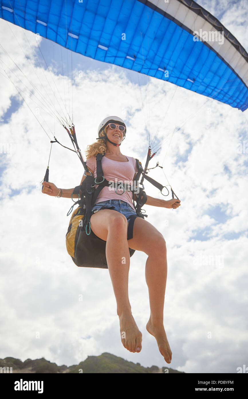 Smiling female paraglider mid-air Stock Photo