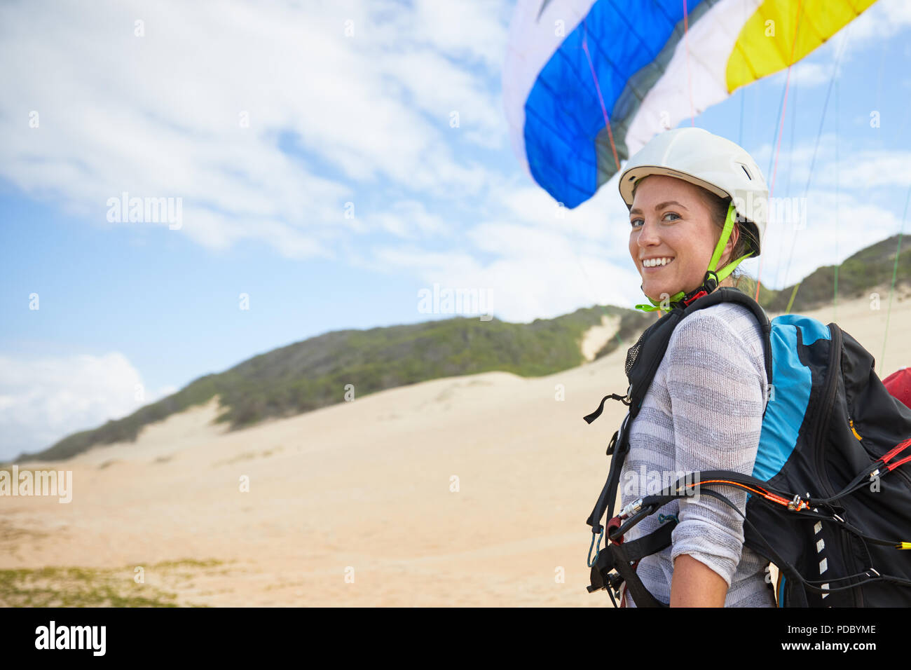 Portrait smiling, confident young female paraglider on beach Stock Photo