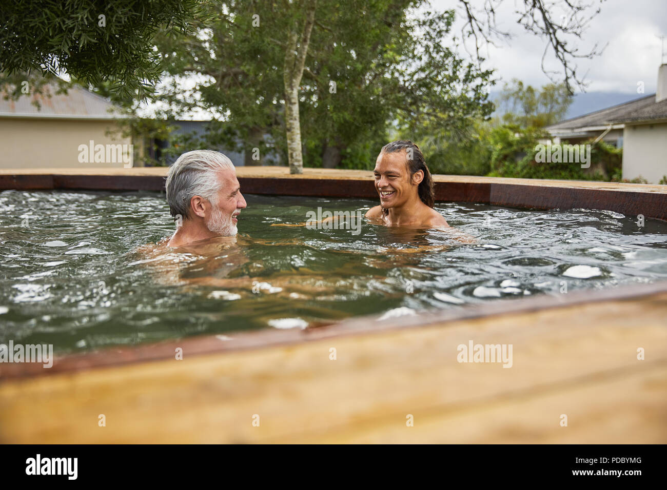 Father and son relaxing in hot tub Stock Photo