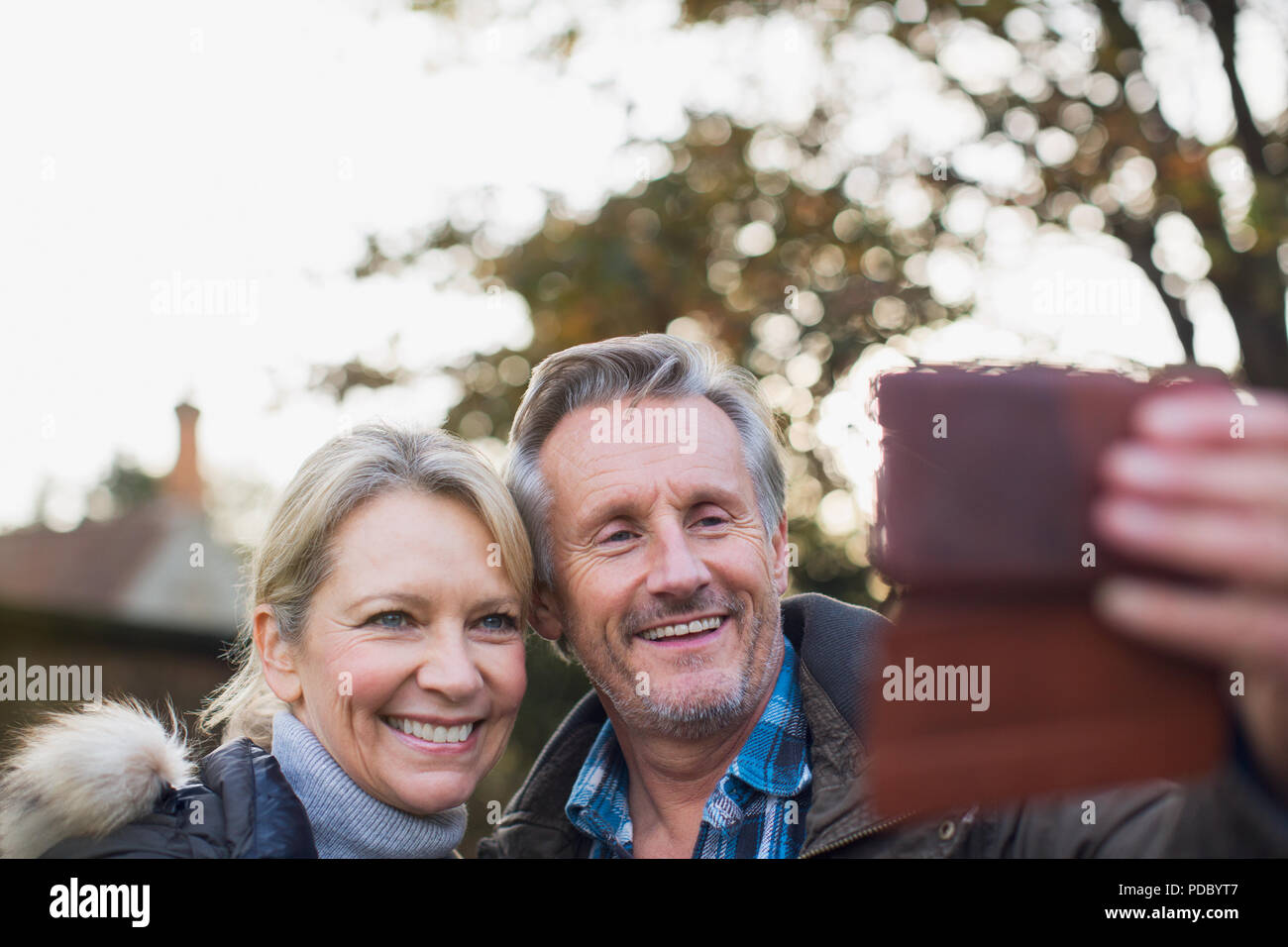 Smiling, happy mature couple taking selfie with camera phone Stock Photo