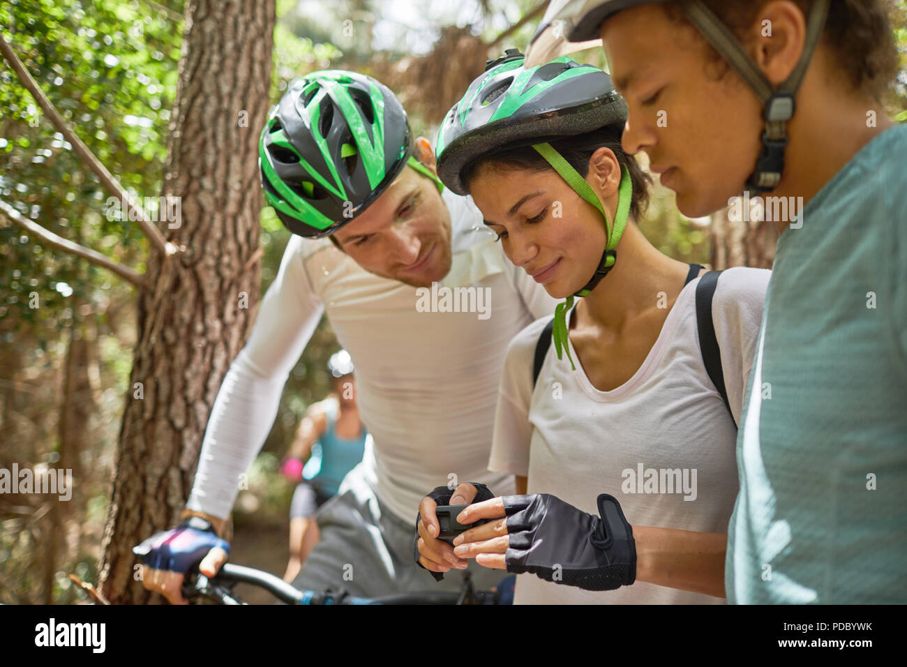 Friends mountain biking, checking wearable camera Stock Photo