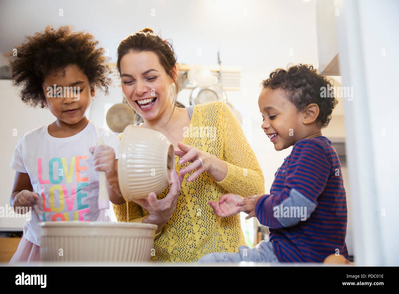 Playful mother and children baking in kitchen Stock Photo