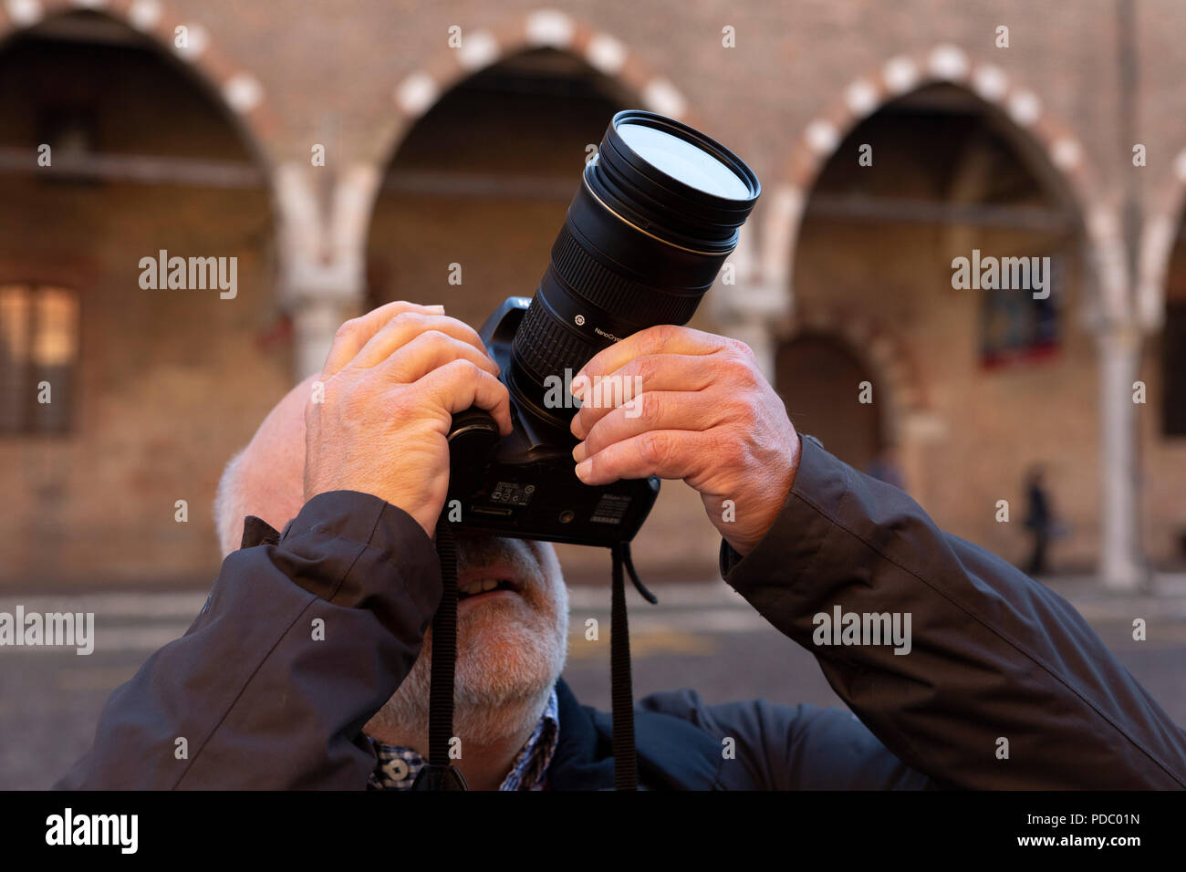 A man photographs details of buildings at Mantua in northern Italy. The city has several medieval edifices. Stock Photo
