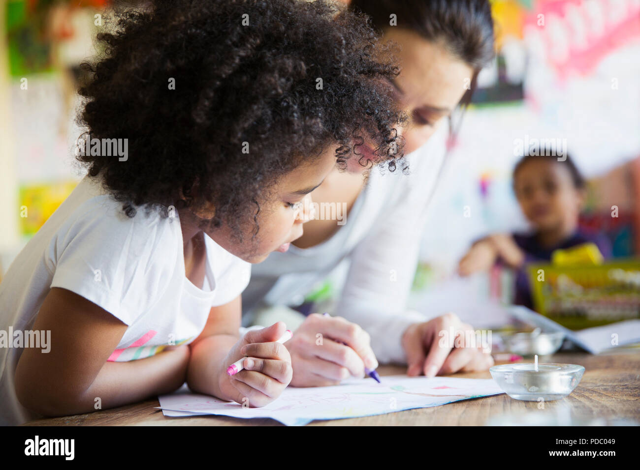 Mother and curious daughter coloring Stock Photo