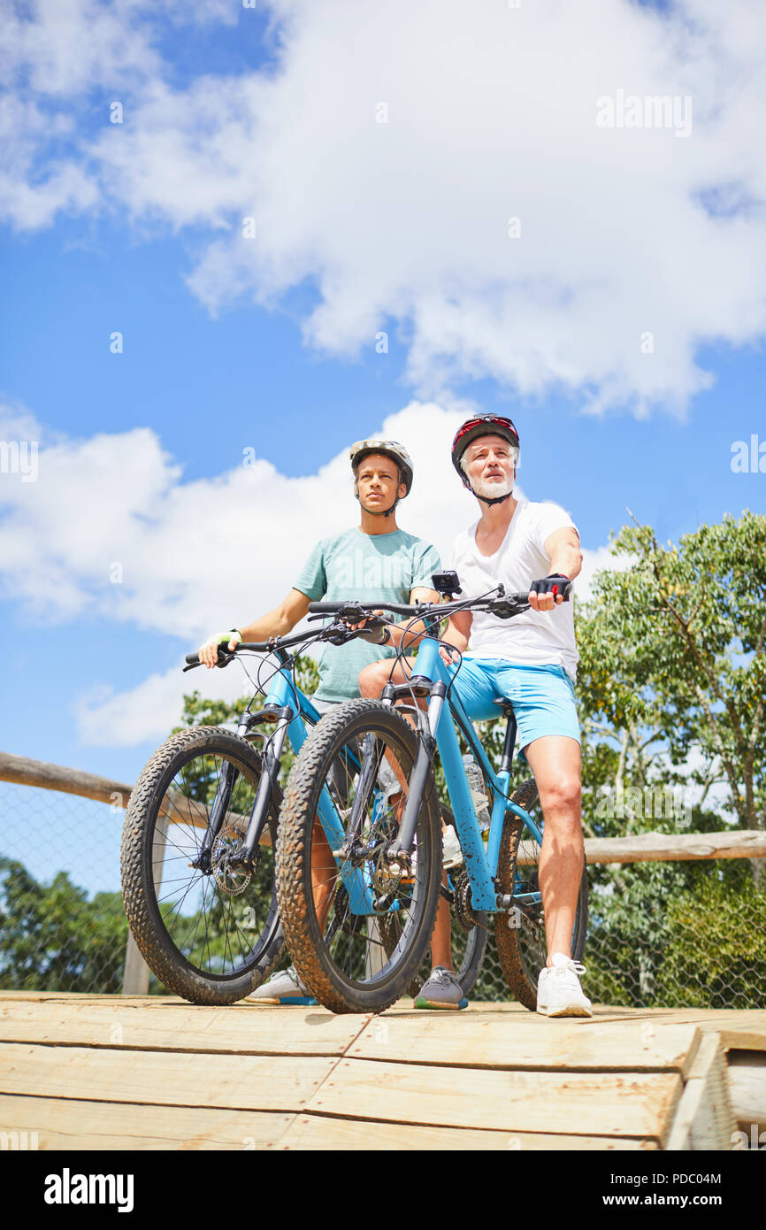Father and son mountain biking at obstacle course Stock Photo