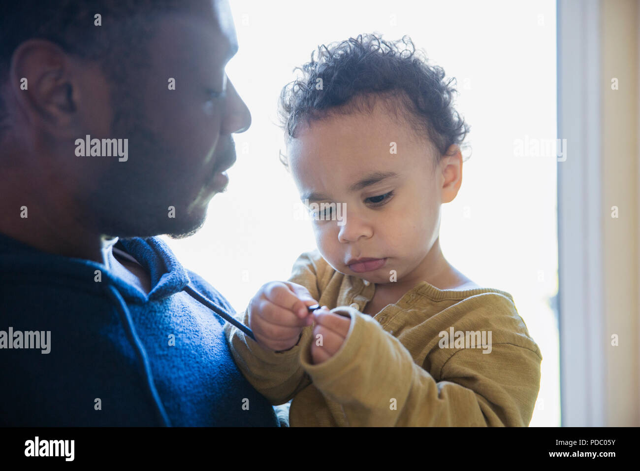 Father holding cute, curious baby son Stock Photo