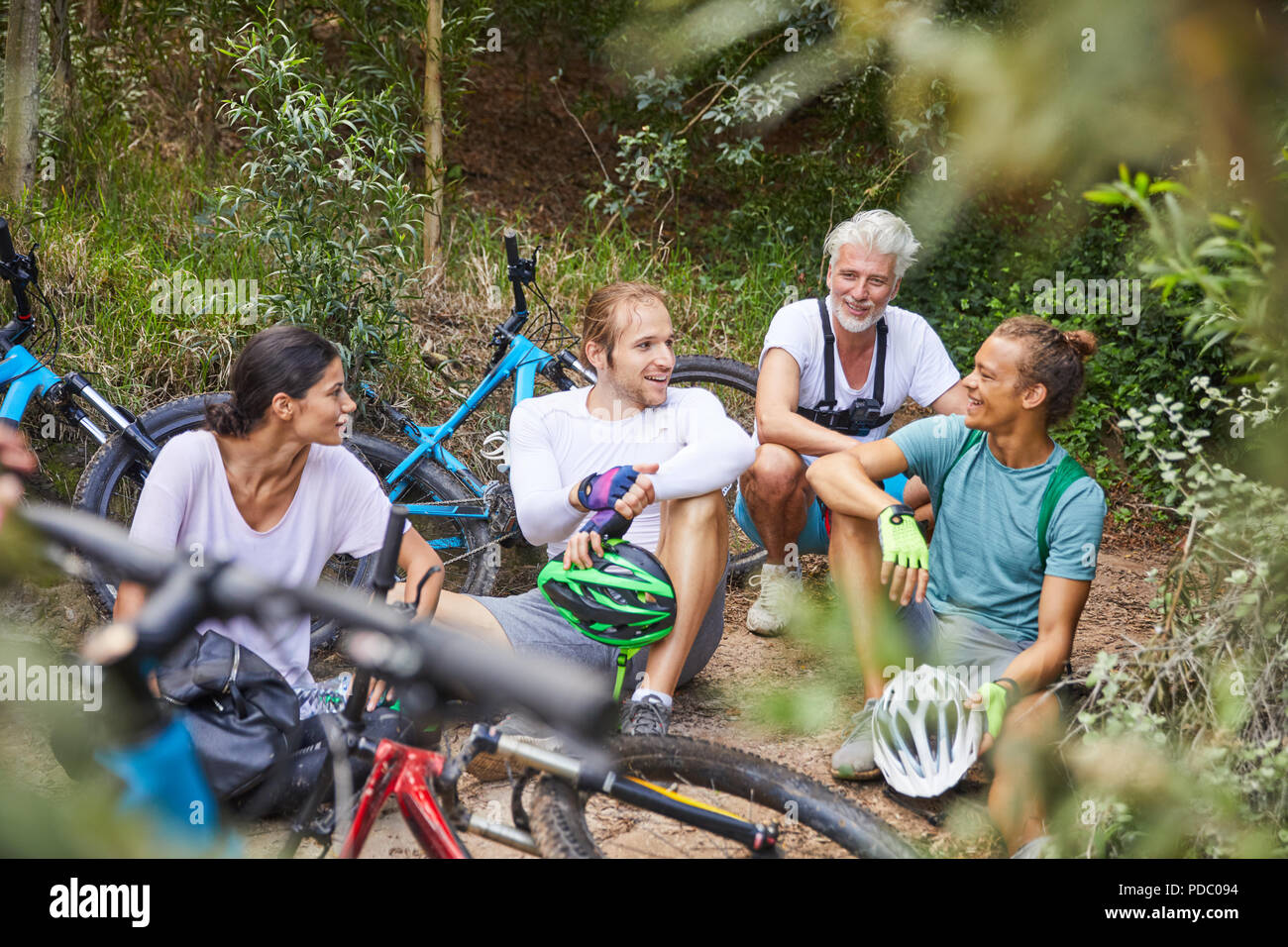 Friends mountain biking, resting in woods Stock Photo