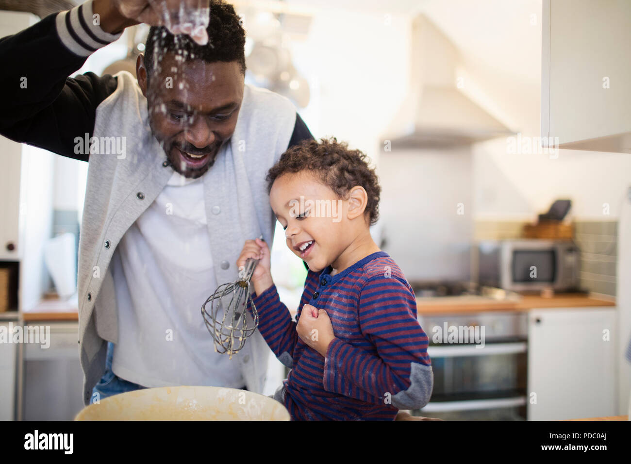 Playful father and son baking in kitchen Stock Photo