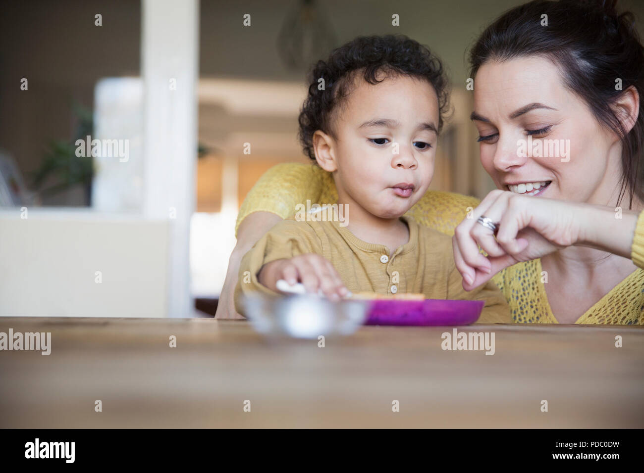 Mother feeding baby son at table Stock Photo